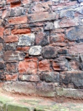The criss-crossed part of the wall are bricks taken from Hadrians Wall